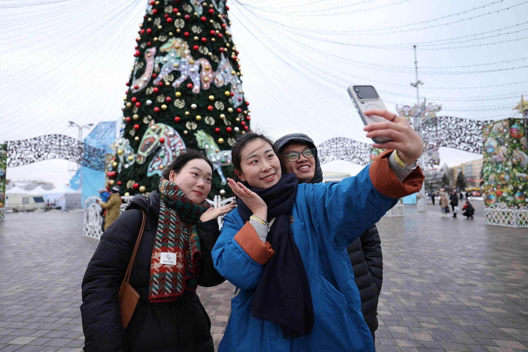 Девушки фотографируются у новогодней елки