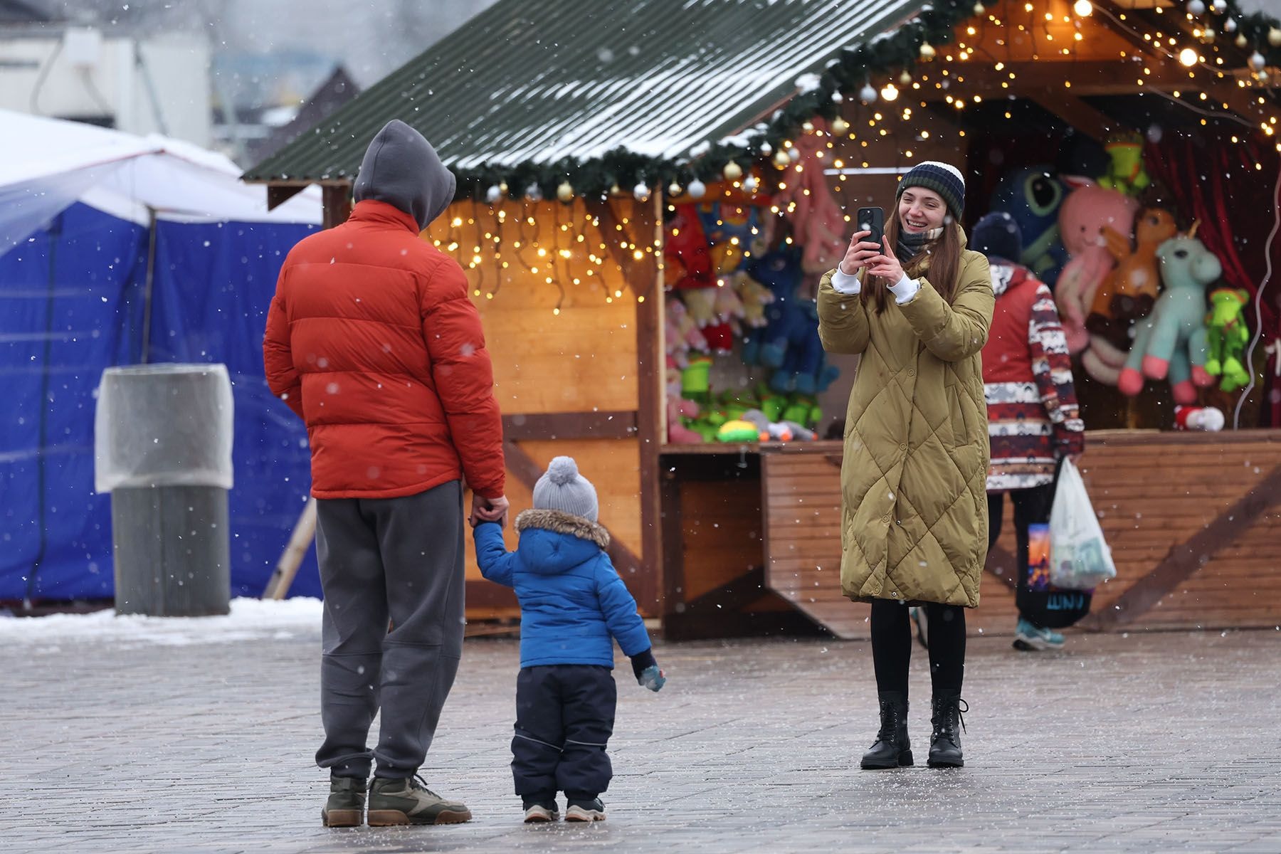 Женщина фотографирует мужа и ребенка