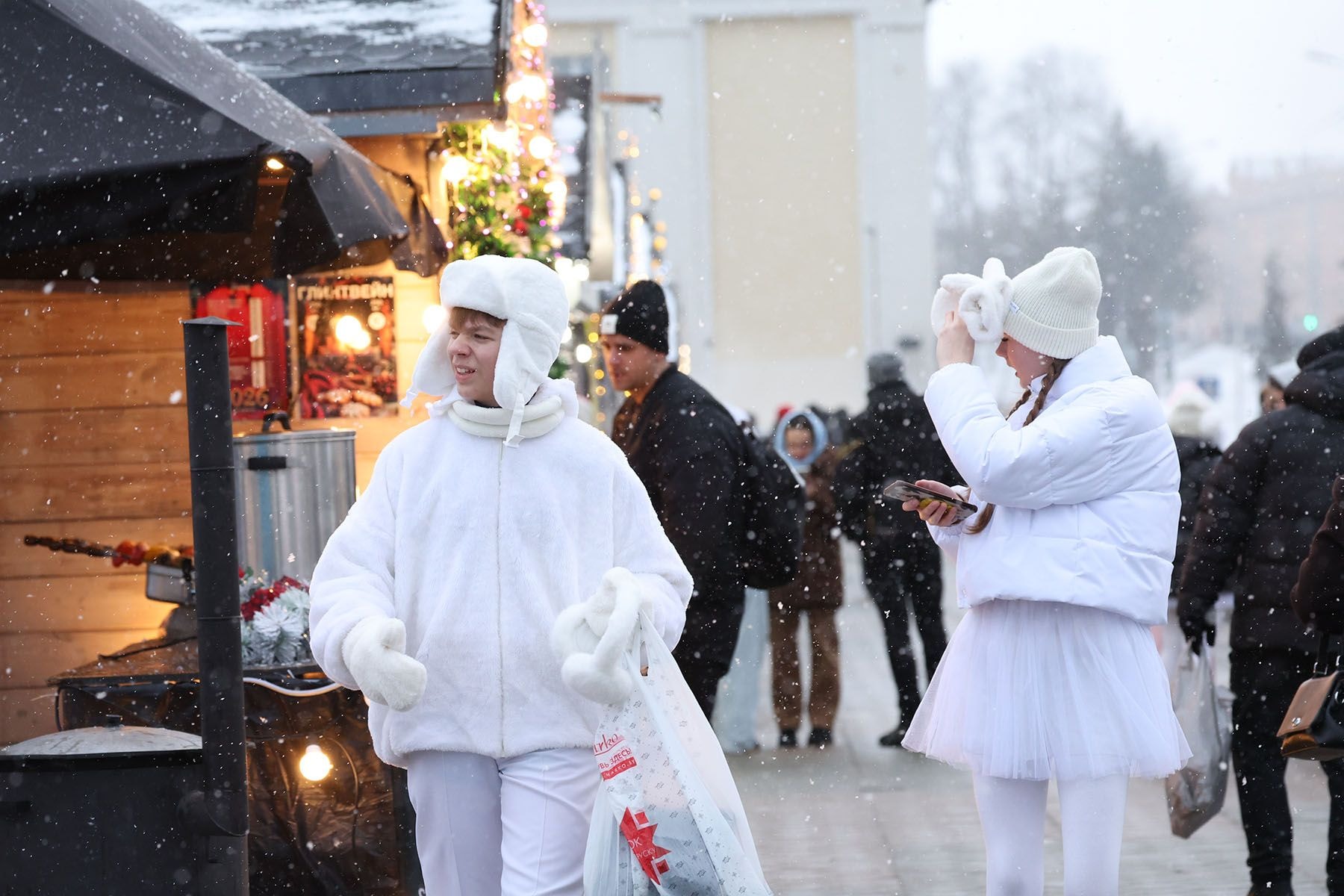 Молодые люди у новогодней ярмарки на проспекте Победителей