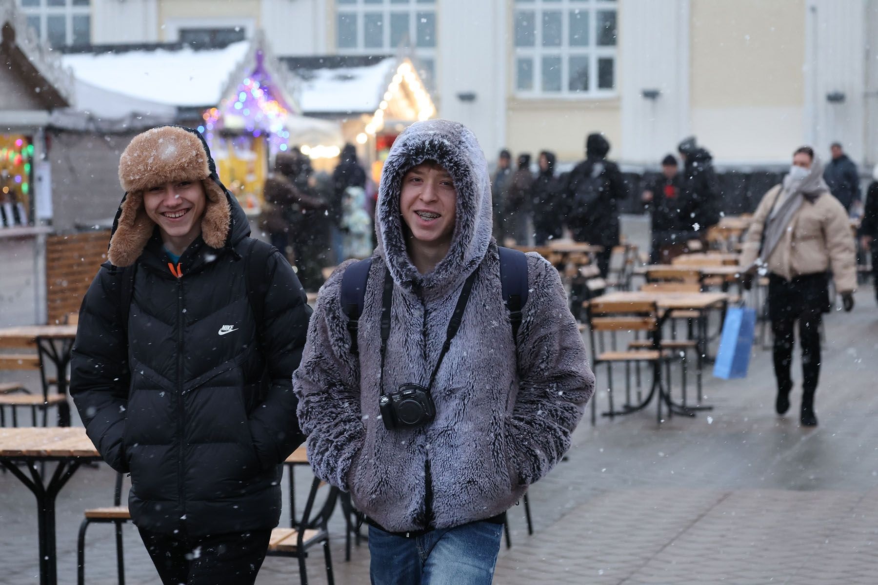 Молодые люди у новогодней ярмарки на проспекте Победителей