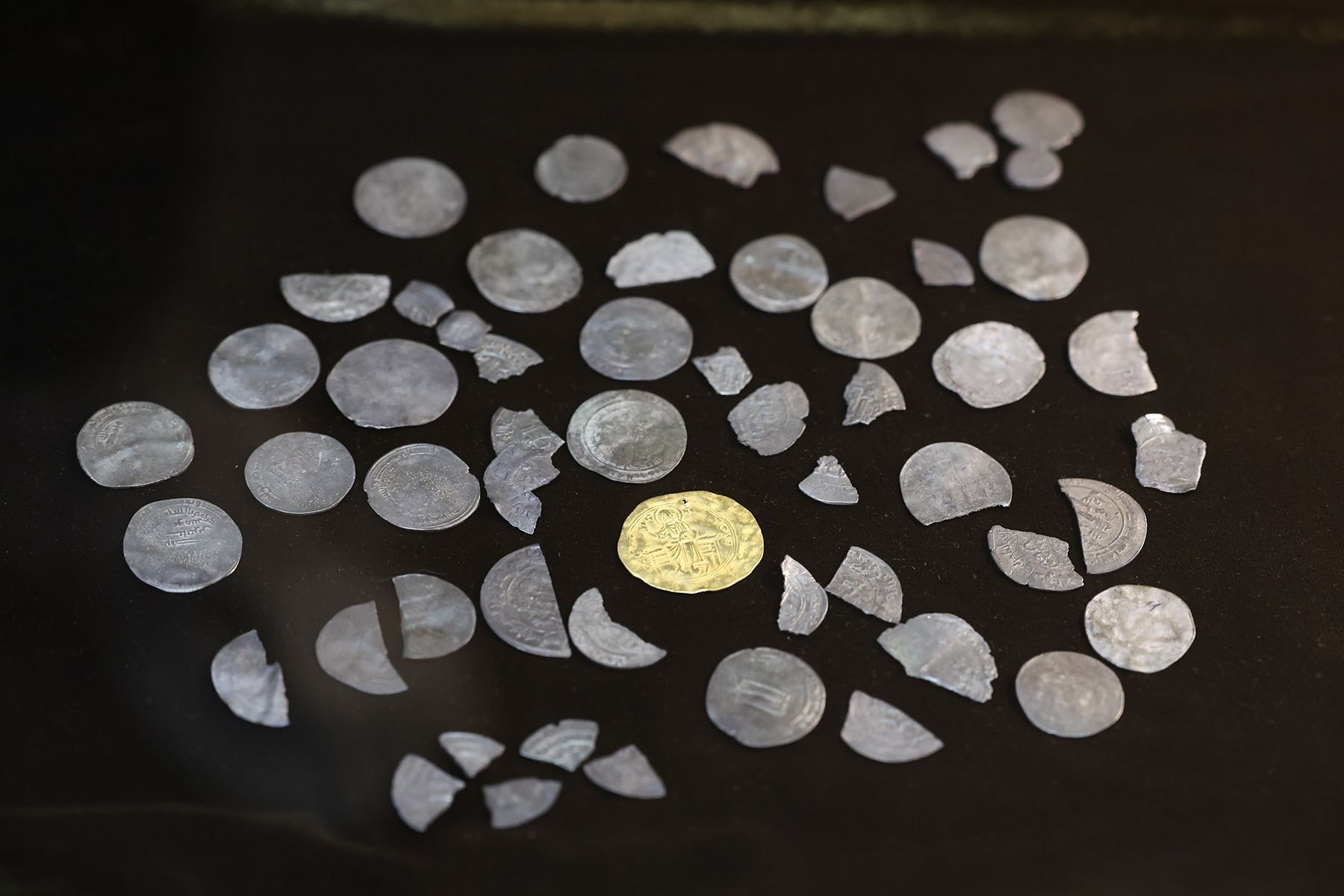 Куфические дирхамы, в центре – золотая византийская монета