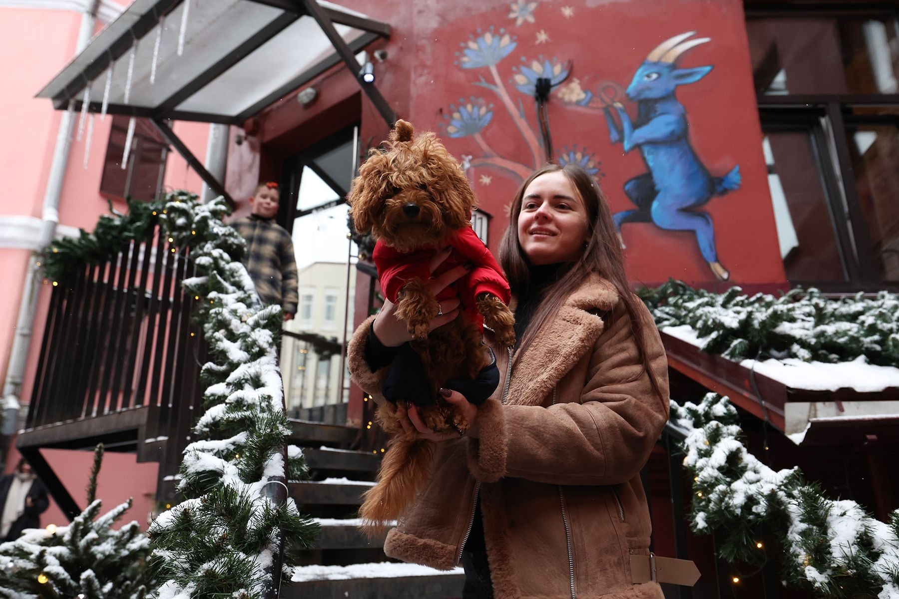 Женщина держит собаку на руках