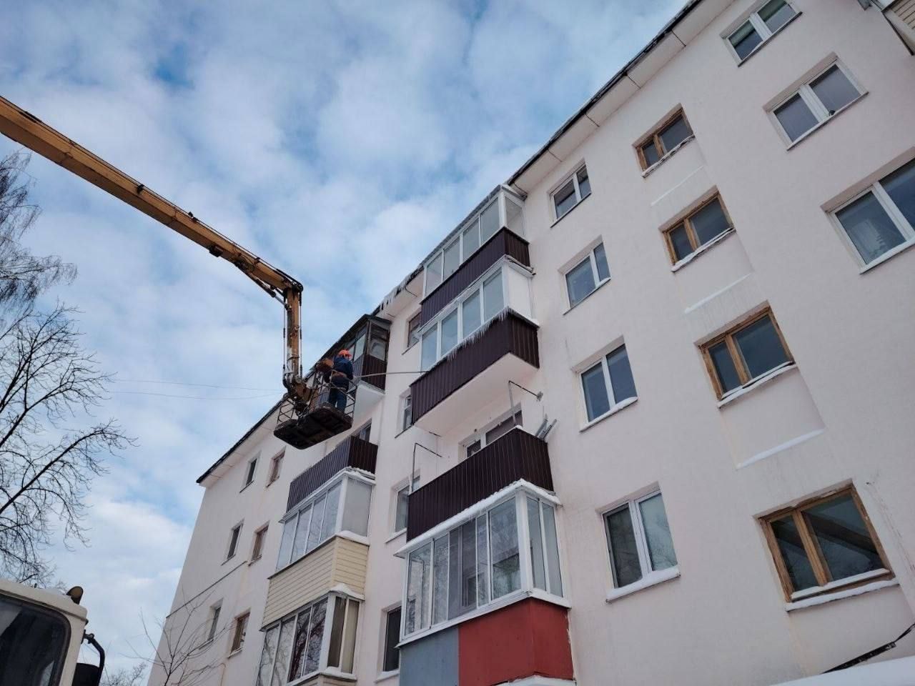 Рабочие убирают сосульки с жилого дома
